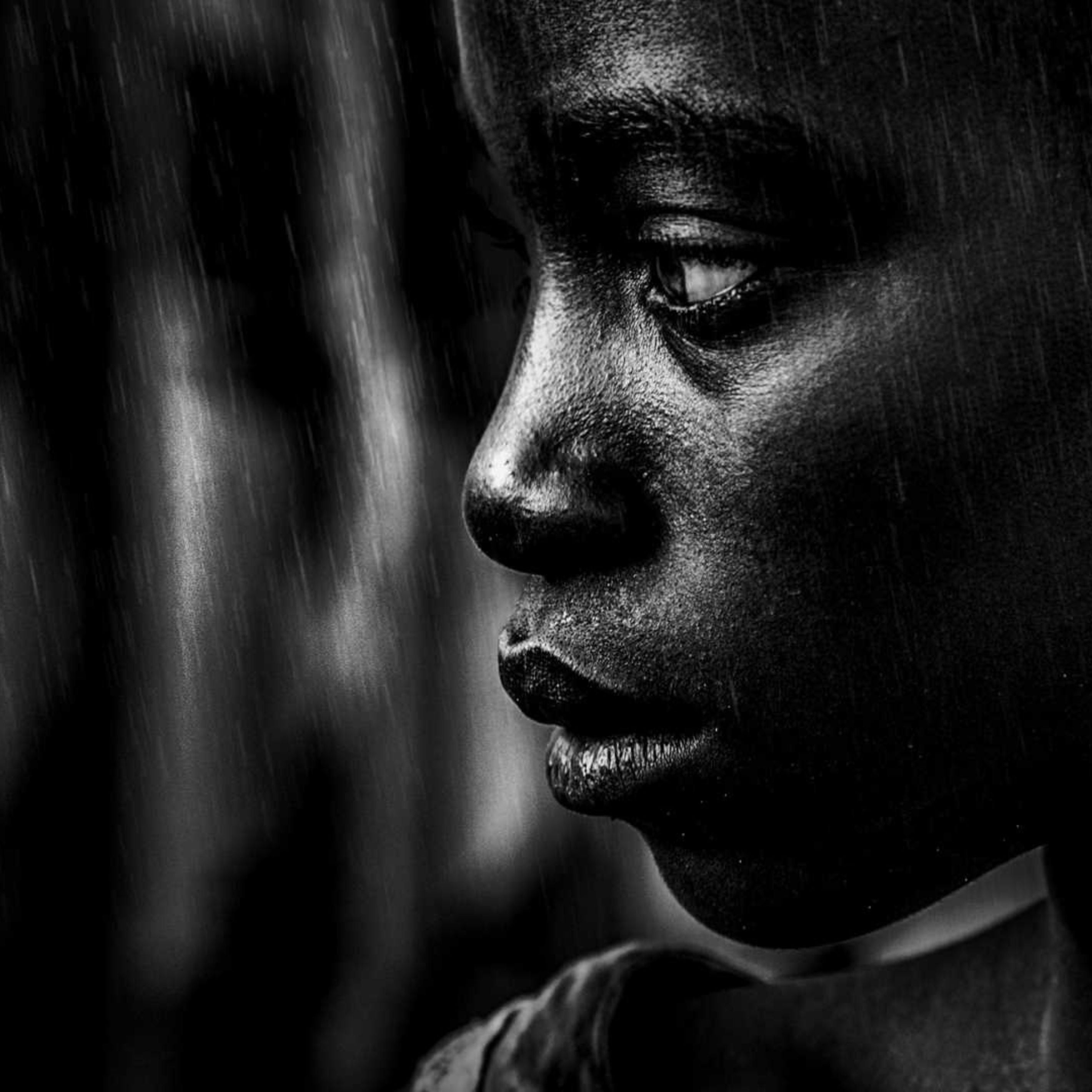 A child looking sad with grey & black background