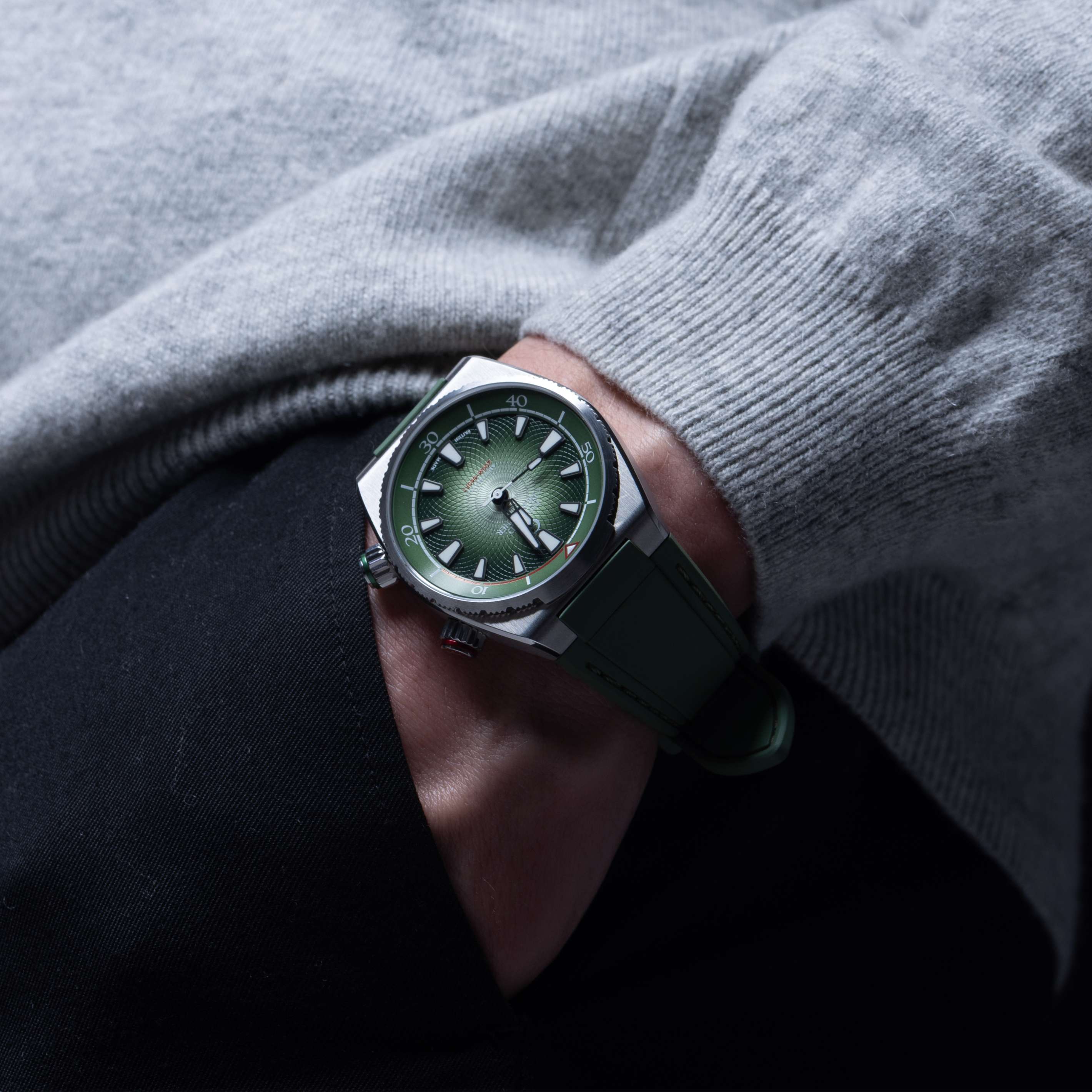 A Forest Green Edward Christopher Manta luxury watch, dive watch & sports watch on a man's wrist by trouser pocket